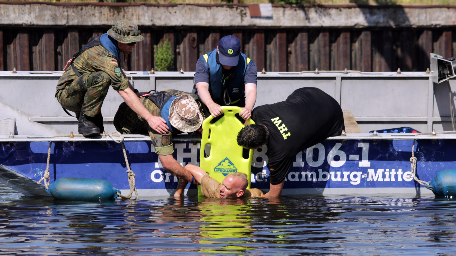 Eine Person in Seenot wird in ein Boot geholt