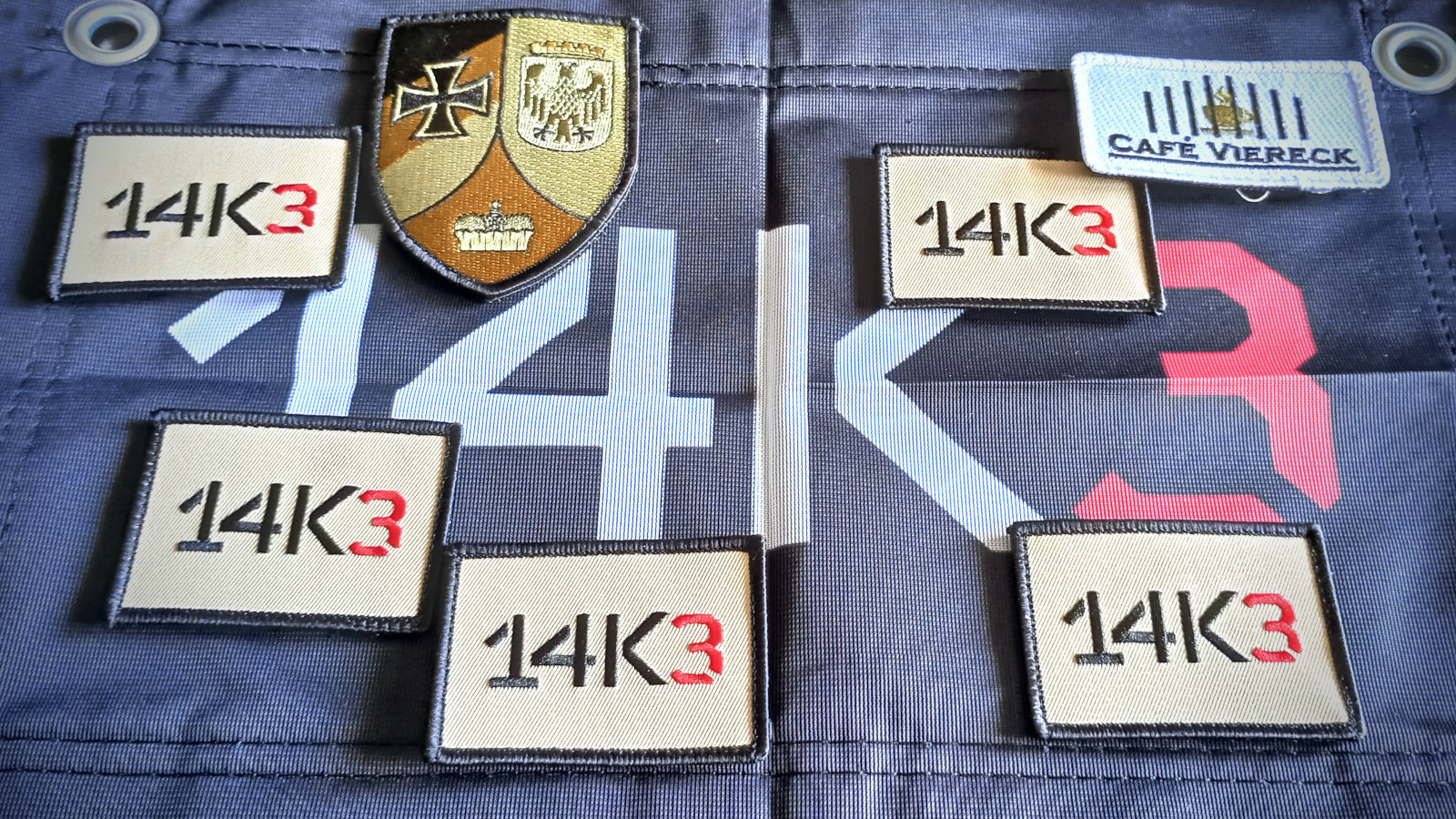 Marschflagge und Spendenpatches des 14K3-Marsches und das Wappen der RK Potsdam.